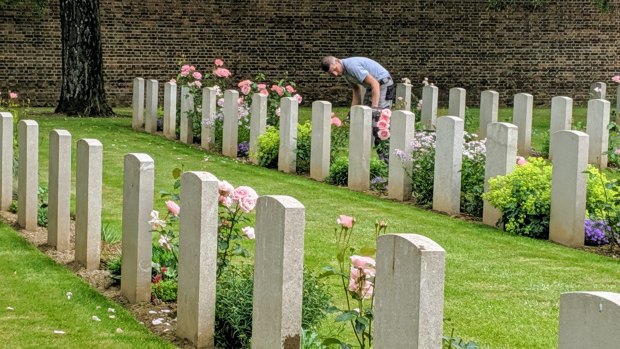 A gardener tends to the upkeep of war graves at the Faubourg D'amiens Cemetery in Arras.