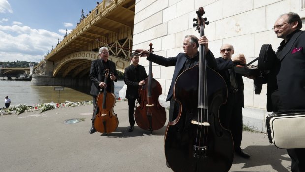 A musical group perform a lament in tribute to the victims on the banks of the Danube River on Saturday.