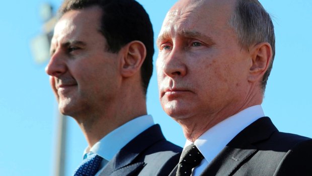 Russian President Vladimir Putin, right, and Syrian President Bashar Assad watch troops marching at the Hemeimeem air base in Syria in 2017.