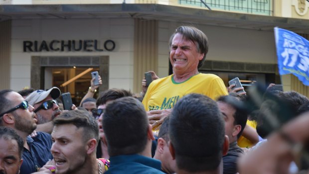 Then presidential candidate Jair Bolsonaro grimaces right after being stabbed in the stomach during a campaign rally in Juiz de Fora, Brazil, in 2018. 