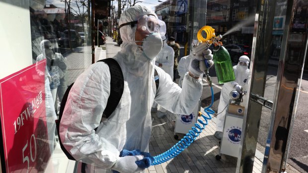 Disinfection professionals wearing protective gear spray anti-septic solution against the coronavirus (COVID-19) on February 27, 2020 in Seoul, South Korea. 