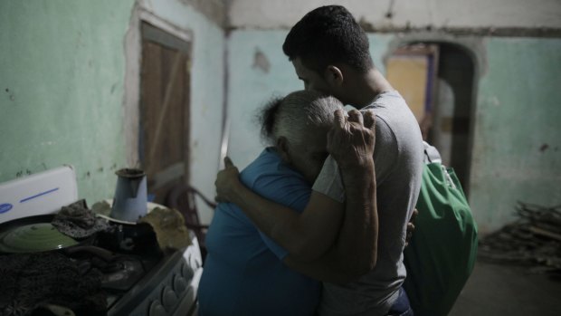 The first Central American asylum seeker sent to Guatemala under that country's "safe third country" agreement with the US, Erwin Jose Ardon, right, is welcomed home by his grandmother Elda Bardales, in Colon, Honduras, in November. He opted to return to his home in Honduras instead.