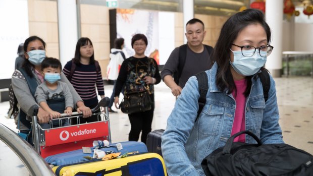 Passengers arrive at Sydney Airport wearing masks. 