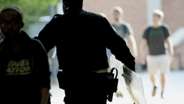 A University of North Carolina, Charlotte campus police officer carries a tactical shield after a shooting in Charlotte, NC. 