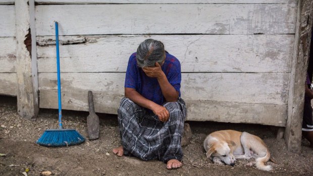 Elvira Choc, 59, Jakelin Amei Rosmery Caal's grandmother, rests her head on her hand in front of her house in Raxruha, Guatemala.