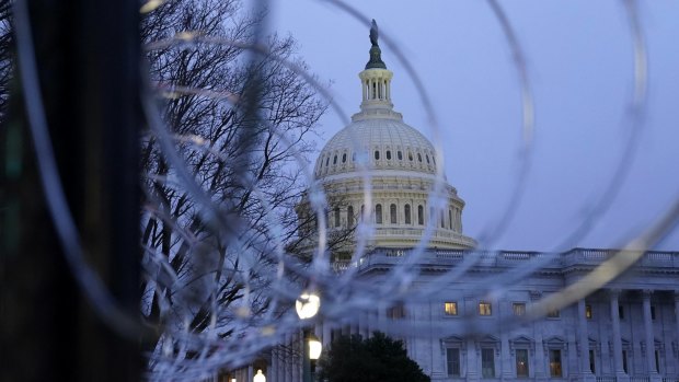The US Capitol dome is seen past security fencing and barbed wire erected after the deadly January 6 riots.