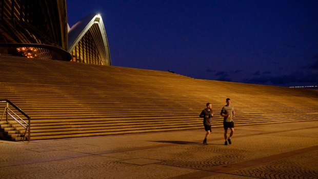 Sydney Opera House is deserted except for distanced joggers.