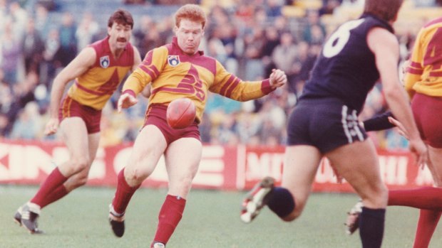 Roger Merrett (Bris) watches as teammate Brad Hardie kicks the ball in a game against Carlton in 1990. 