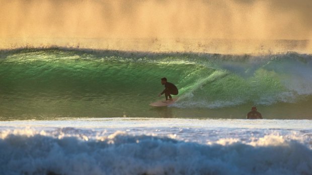 Surfers use the growing swell along the Sydney coast. 