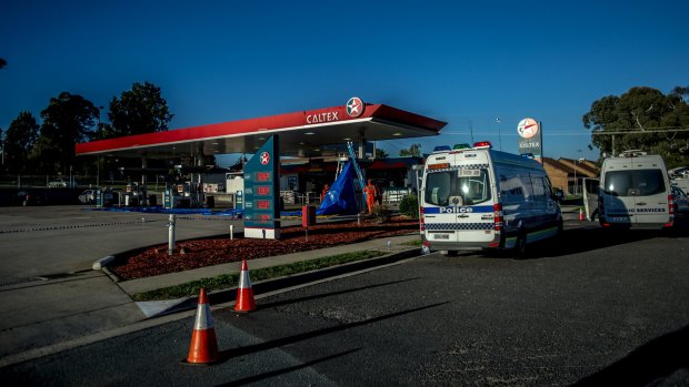 Police and SES volunteers at the Caltex service station where Mr Akbar was murdered.