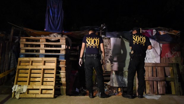Police look at the body of Rolito Nunez at the crime scene in Barangay Old Balara, Quezon City in April, 2017. 