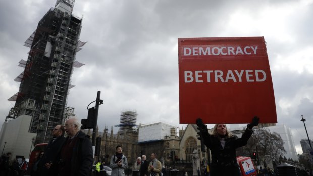 A pro-Brexit supporter holds up a placard outside the Houses of Parliament.