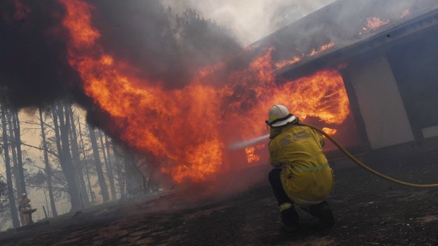 Firefighters work to save a property in the NSW Southern Highlands on Thursday. 