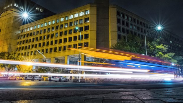 Traffic streaks past the FBI headquarters along Pennsylvania Avenue in Washington.