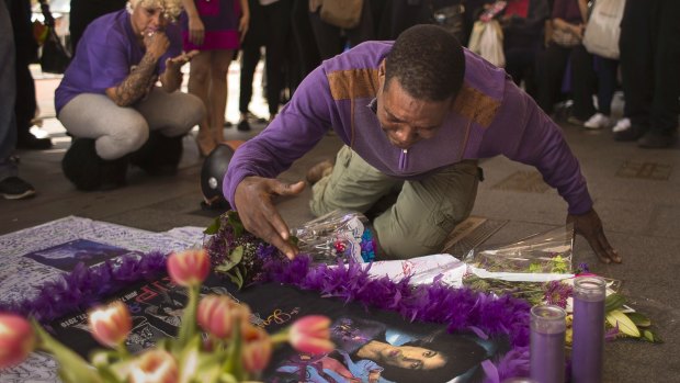 A fan cries at a makeshift memorial created in remembrance of singer Prince outside Apollo Theatre in New York , Friday, April 22, 2016.