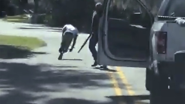 Ahmaud Arbery stumbles and falls to the ground after being shot as Travis McMichael stands by holding a shotgun in a neighbourhood outside Brunswick, Georgia. 