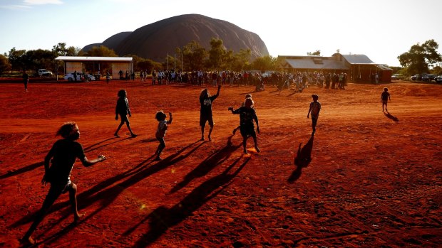 Children playing footy during the closing ceremony of a Mutitjulu community in Uluru.