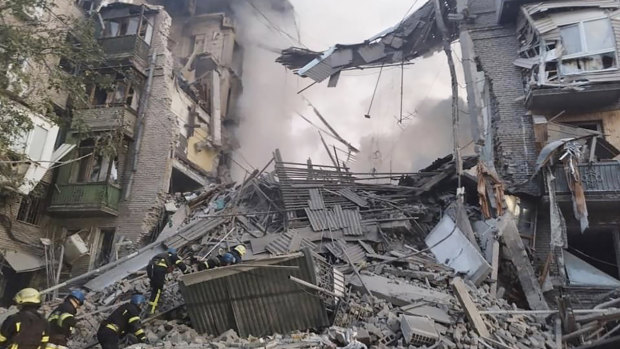 Rescuers work at the scene of a building damaged by shelling in Zaporizhzhia, Ukraine.