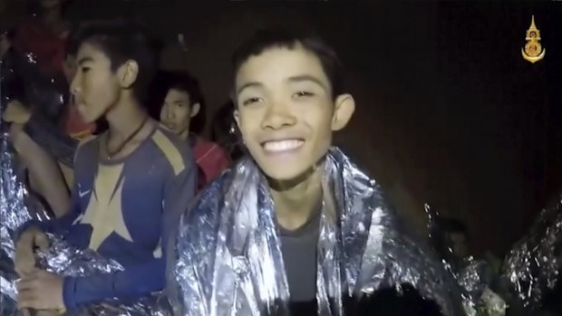 A member of the soccer team smiles as Thai Navy SEAL medics help injured children inside a cave in Mae Sai, northern Thailand.