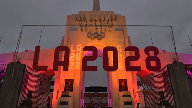 An LA2028 sign is seen in front of a blazing Olympic cauldron at the Los Angeles Memorial Coliseum.