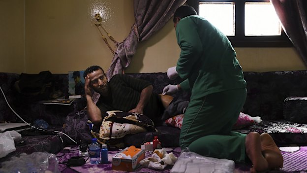 Syrian Democratic Forces soldier Shiyar Noushtiman has his wound dressed at a house in Hasaka where SDF soldiers are recuperating from injuries sustained fighting IS. 