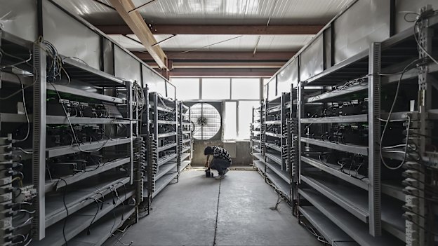 A technician inspects bitcoin mining machines at a mining facility in inner Mongolia.