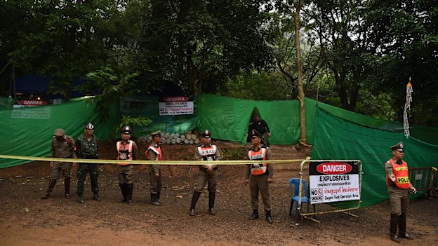 Thai police guard the entrance to the track leading to Tham Luang cave.