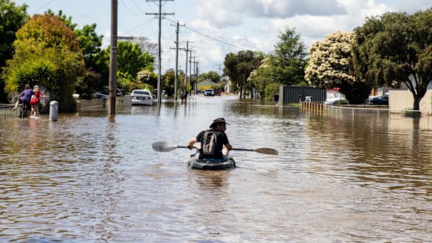 A local resident paddles through a flooded street in Shepparton, Victoria, in 2022, during a flood that destroyed 80 homes.