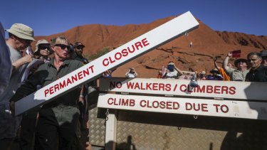 Ranger Lynda Wright places the new sign of the permanent closure of the Uluru climb.
