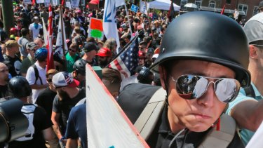 A white nationalist demonstrator with a helmet and shield walks into Lee Park in Charlottesville, Virginia in 2017.