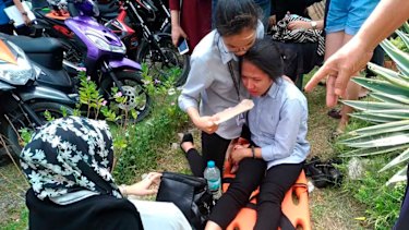 A woman on a stretcher is assisted after a powerful earthquake was felt in Davao City, Philippines, on Tuesday.