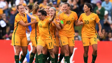 Lisa De Vanna celebrates a goal with her green-and-gold teammates.