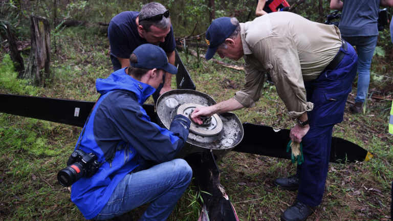 ATSB investigators and police examine the propeller that fell off an aircraft on approach to Sydney Airport.