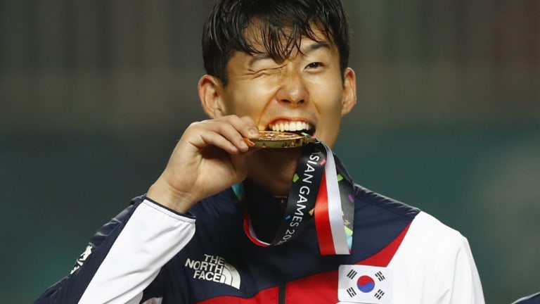 Exemption: South Korea's Son Heung-min celebrates on the podium after winning the Asian Games gold medal.