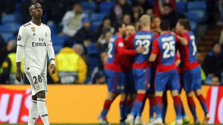 Real Madrid forward Vinicius Junior looks on as CSKA players celebrate.