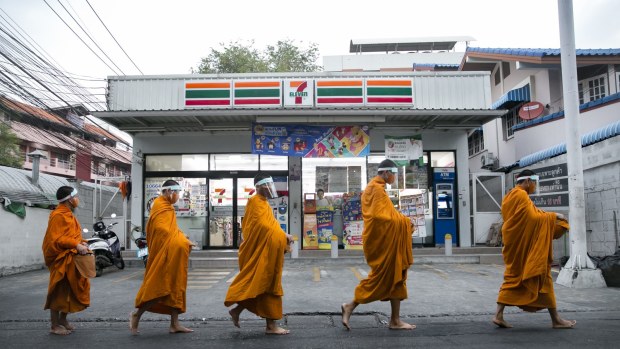 Buddhist monks collect alms in Bangkok  during the pandemic.