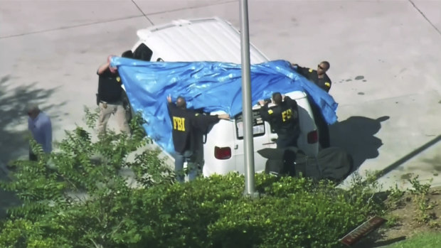 FBI agents cover a van parked in Plantation, Florida.