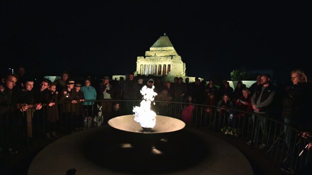People gather at The Eternal Flame for Anzac Day dawn service.