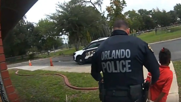 Orlando Police Officer Dennis Turner leads 6-year-old Kaia Rolle away after her arrest for kicking and punching staff members at the Lucious & Emma Nixon Academy Charter School in Orlando, Florida.