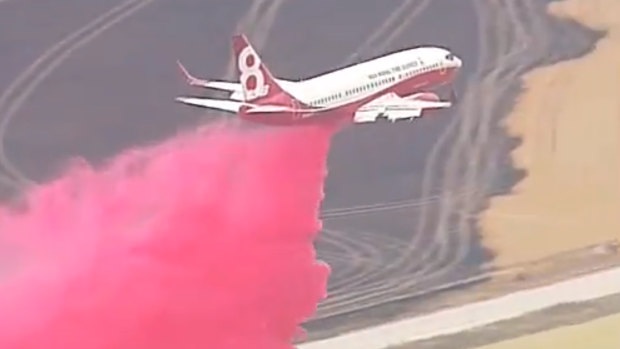 An air tanker drops pink fire retardant over properties in South Australia. 