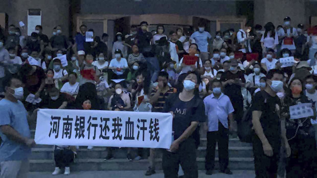 Demonstrators outside the People’s Bank of China in Zhengzhou, Henan province.