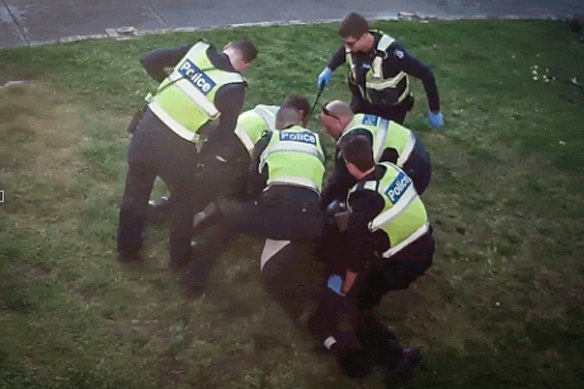 An image from CCTV showing police pinning pensioner John to the ground.