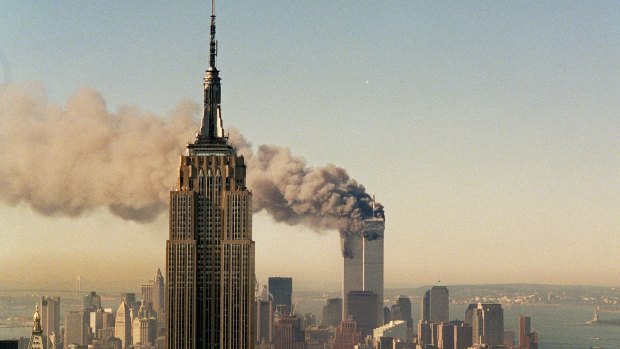 The twin towers of the World Trade Center burn behind the Empire State Building on September 11, 2001. 