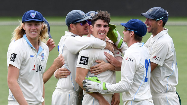 NSW players mob Sean Abbott after the Blues quick ripped through the Tasmanian batsman.