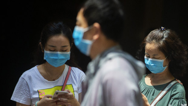 People wearing masks in Sydney CBD as health authorities work to contain an outbreak of COVID-19. 