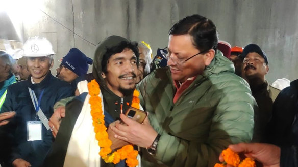 Singh Dhami, right, Chief Minister of the state of Uttarakhand, embraces a worker rescued from the site of an under-construction road tunnel that collapsed in Silkyara in the northern Indian state of Uttarakhand.