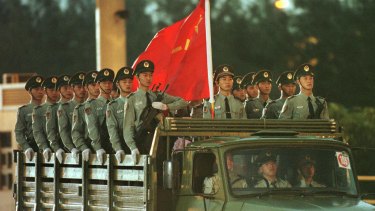 Chinese troops enter at the Luk Ma Chau border between China and Hong Kong in the New Territories to take up positions in China's newly reclaimed territory in July 1997.  
