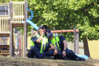Police officers comfort each other at the scene of a tragic jumping castle accident at Hillcrest Primary School in Devonport that left five children dead. 
