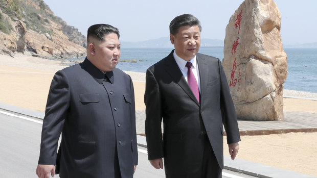 Chinese President Xi Jinping, walks with North Korean leader Kim Jong-un during a meeting in Dalian.