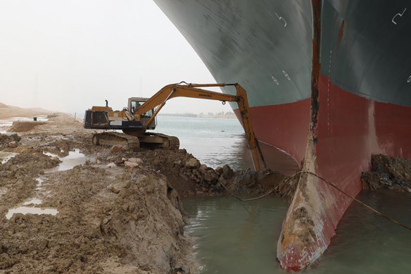 A backhoe tries to dig out the keel of the Ever Given.